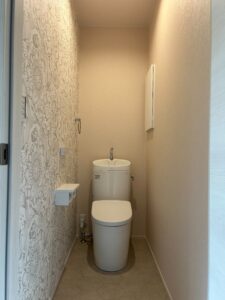 滋賀の平屋トイレ｜テクスチャ壁紙と手洗い付きトイレのシンプルな空間｜つなぐハウス