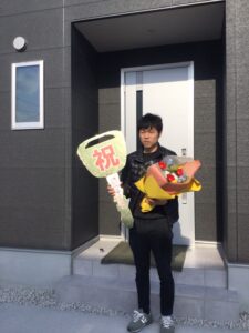 滋賀県の平屋新築住宅引き渡し式｜祝い鍵と花束を持つオーナー様と平屋玄関