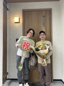 滋賀県で注文住宅の平屋を新築されたご夫婦。白い外壁と木目調の玄関ドアが特徴の平屋お引渡し式。